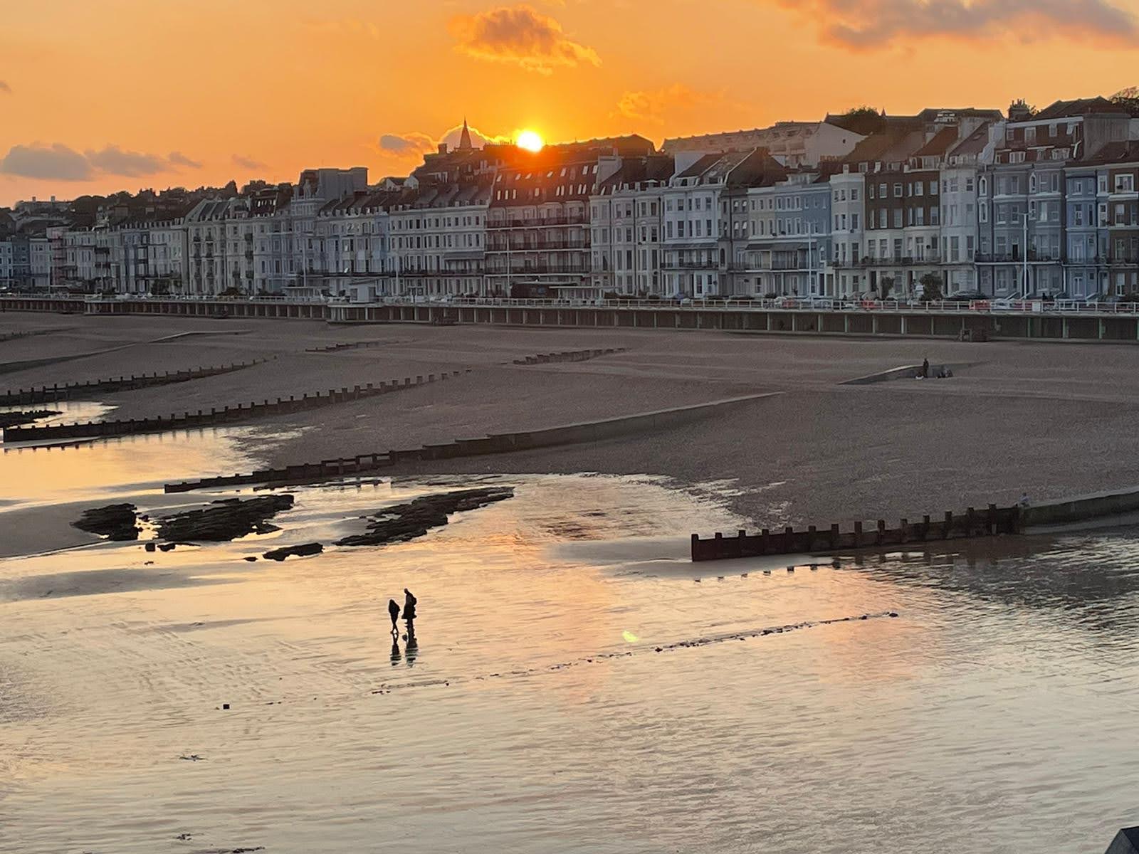 Sunset over beach with silhouettes
